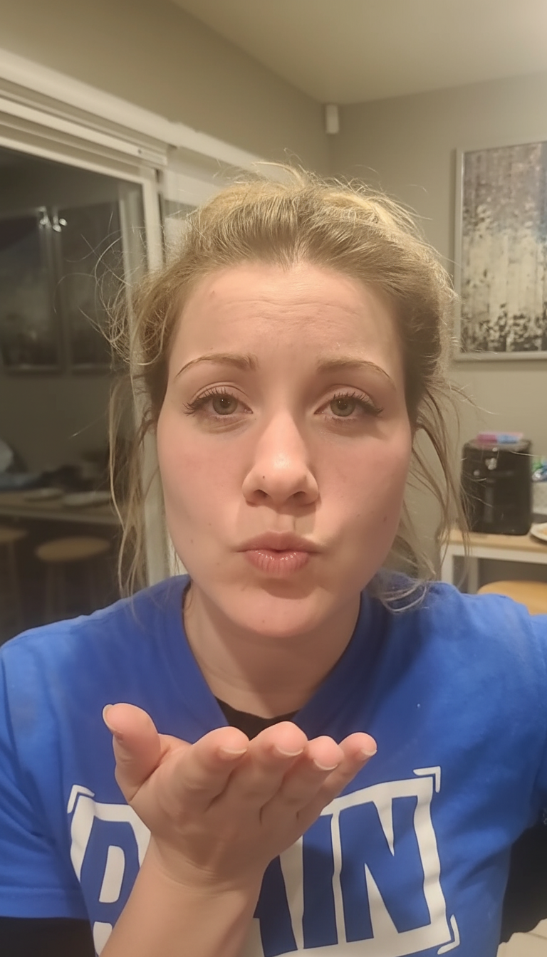 Transition to a pouty face with pursed lips blowing a kiss.